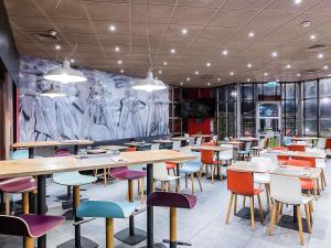 加亚新城波尔图盖亚诺宜必思酒店的一间有桌椅和壁画的餐厅