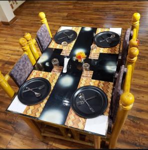 a table with black plates on top of it at Hotel Bali Inn in Agra