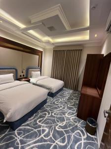 a hotel room with two beds and a piano at العييري ريزيدنس in Dammam