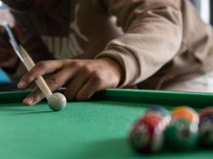 Ein Mann spielt Billard mit einem Queue auf einem Billardtisch in der Unterkunft ibis Cannes Centre in Cannes