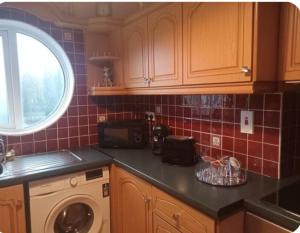 a kitchen with a sink and a washing machine at Kathleen's Apartment includes Car Parking in Galway