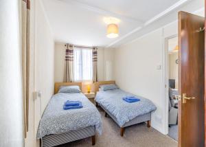 two beds in a small room with a bathroom at Ravenna Holiday Park in Anderby