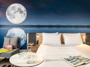 une chambre avec un grand lit et une pleine lune dans l'établissement Novotel Marne-la-Vallée Noisy-le-Grand, à Noisy-le-Grand