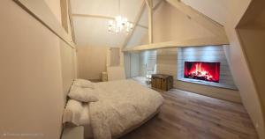 ein Schlafzimmer mit einem Bett und einem Kamin in der Unterkunft Villa pour 24h auto le mans in Teloché + 3 Fotos