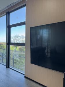 Un televisor de pantalla plana grande en el costado de una pared. en Galactic getaways MARS, en Prestatyn