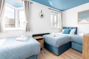 une chambre avec deux lits jumeaux et une fenêtre dans l'établissement Spacious 5 Bedroom 2 Bathroom Home with 12 Beds and Private Driveway Parking, à Manor