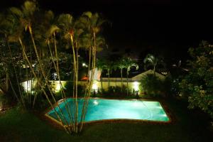 a swimming pool at night with palm trees and lights at Driftwood on 10 in Durban