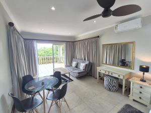 a living room with a couch and a table and chairs at Driftwood on 10 in Durban