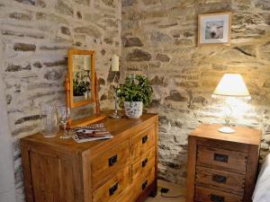 a bedroom with a wooden dresser with a mirror on it at Penno Cottage - 24440 in Bodmin