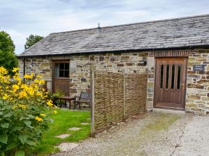 an old stone building with a wooden door at Penno Cottage - 24440 in Bodmin +1 photo