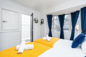 a bedroom with a large bed with blue curtains at Spacious 4 Bedroom House with 8 Beds and Private Driveway Parking in Heeley