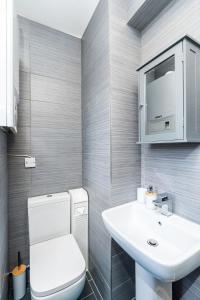 a bathroom with a white toilet and a sink at Spacious 4 Bedroom House with 8 Beds and Private Driveway Parking in Heeley