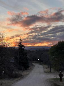 una strada sterrata con un tramonto nel cielo di Cabaña Carmanqui ad Alpa Corral