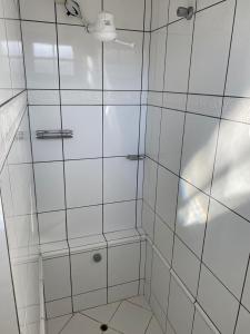 a shower with white tiled walls and a ceiling at Hostel da Dani in Balneário Camboriú