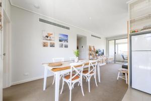 a kitchen with a table and chairs and a refrigerator at Sanny Side Up in San Remo
