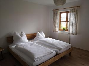 a bedroom with two beds with white sheets and a window at Appartement Panoramablick in Grattersdorf