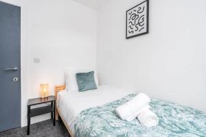 a bedroom with a bed with towels on it at 4 Bedroom House with 2 Bathrooms - Back Garden with Outdoor Seating Sleeps 7 in Heeley