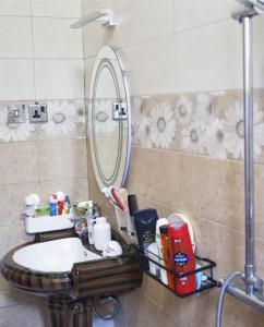 une salle de bains avec un lavabo et un miroir dans l'établissement Daud Monica Staycation Home, à Manyema