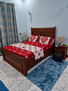 une chambre avec un lit aux oreillers rouges et blancs dans l'établissement Daud Monica Staycation Home, à Manyema