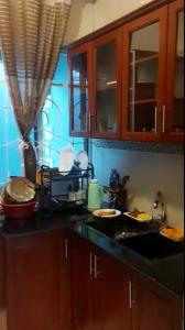 une cuisine avec des armoires en bois et un comptoir noir dans l'établissement Daud Monica Staycation Home, à Manyema 4 autres photos