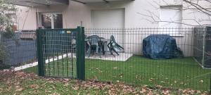 a green fence in front of a house at Appartement Lanton in Lanton