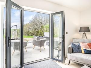 a sliding glass door leading to a patio with a couch at Cefn Gelli in Clynderwen
