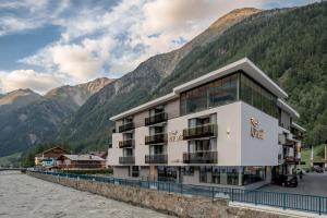 a building next to a river with mountains at Regina's Alp deluxe in Sölden