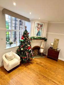 un arbre de Noël dans un salon avec une cheminée dans l'établissement The Coach House - Grade 2 Listed, à Hale