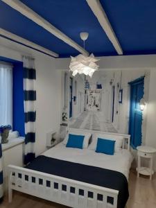 a bedroom with a white bed and blue ceilings at Capitals Residence in Oświęcim