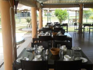 a restaurant with black tables and chairs and a large window at Le Choisy Mauritius in Mont Choisy
