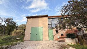 a house with a green door in a field at Provençal Getaway Pool Studio Hiking in Taulignan