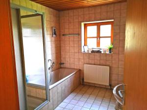 a bathroom with a bath tub and a window at Appartement Panoramablick in Grattersdorf +15 photos