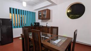 a dining room with a table and a mirror on the wall at MPR villa in Tangalle