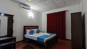 a bedroom with a bed and a red curtain at MPR villa in Tangalle