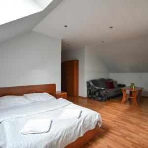 a bedroom with a large bed and a chair at Zajazd Pasja in Sławków +45 photos