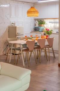 a white kitchen with a table and chairs at 온유재스테이 N seoul tower 800m in Seoul