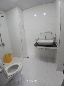 Un baño blanco con inodoro y lavabo. en Sky Mount Hotel Patriata, en Patriata