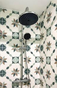 a shower in a bathroom with green and white tiles at Le Sicile -Appartement agréable à Lespignan in Lespignan