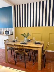 a dining room with a wooden table and chairs at Le Sicile -Appartement agréable à Lespignan in Lespignan +10 photos