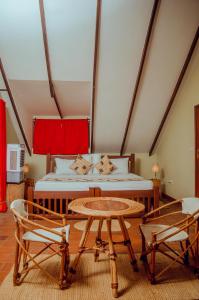 a bedroom with a bed and a table and chairs at Amani Farmhouse in Usa River