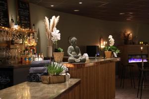 a bar with a statue of a buddha on the counter at Apartments Klövsjöfjäll in Klövsjö