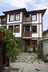 a house with a stone walkway in front of it at Hotel Old Times in Asenovgrad