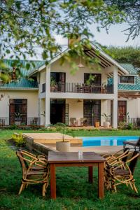 a house with a table and chairs in front of it at Amani Farmhouse in Usa River