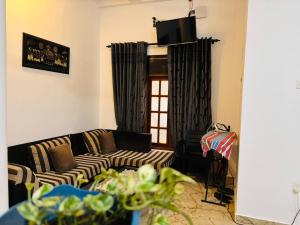a living room with a couch and a tv at Ashford Beach in Matara