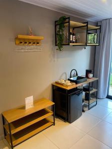 ein Büro mit einem Schreibtisch, einem Waschbecken und einem Tisch in der Unterkunft Pousada Aurora - Com Lindo Jardim em Termas do Gravatal in Gravatal