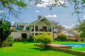 a house with a swimming pool in a yard at Amani Farmhouse in Usa River