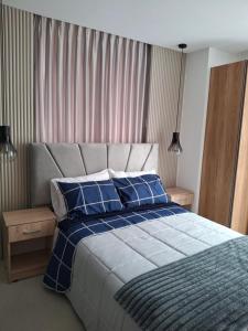 une chambre avec un grand lit avec des oreillers bleus dans l'établissement Oma Deluxe, à Hacienda Carolina