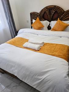 un lit avec deux serviettes blanches posées dessus dans l'établissement twin paradise homes, à Nairobi 13 autres photos