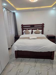 une chambre avec un grand lit avec des draps blancs dans l'établissement twin paradise homes, à Nairobi