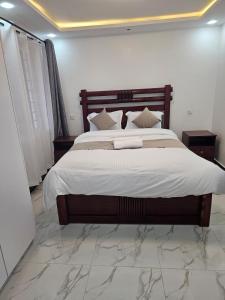 une chambre avec un grand lit avec des draps blancs dans l'établissement twin paradise homes, à Nairobi
